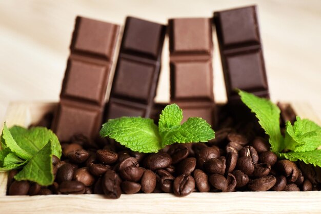 Still life with set of chocolate in wooden box of coffee grains closeup