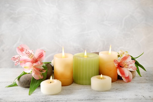 Still life with spa candles on light wallpaper background