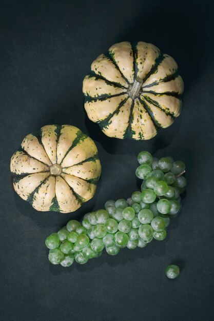 Still life with two decorative pumpkins and a bunch of grapes