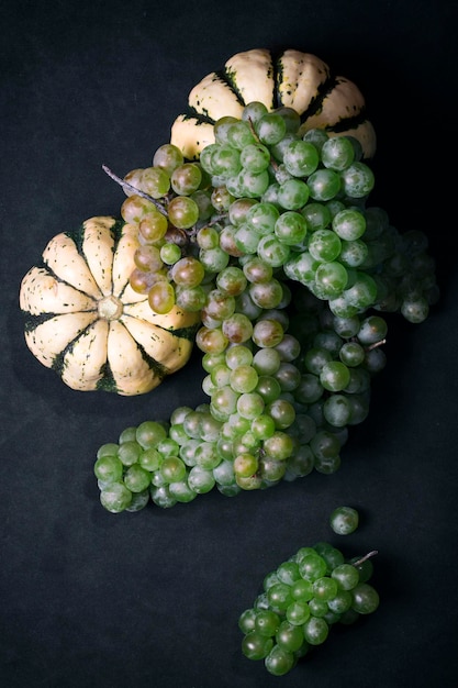 Still life with two decorative pumpkins and bunches of grapes