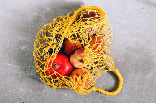 Still life of yellow biodegradable shopping bag with raw fruit