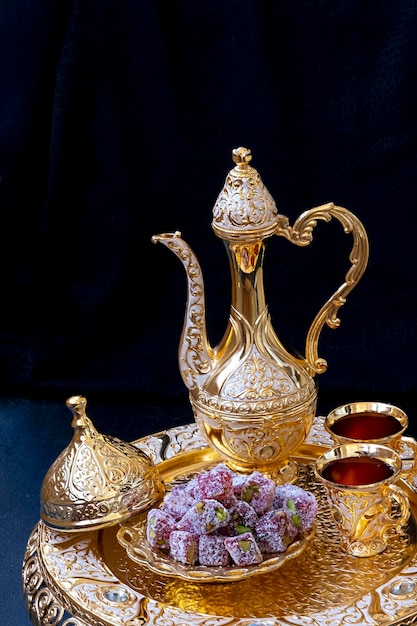 Stilllife with traditional golden arabic coffee set with jezva cup and sweets Ramadan concept