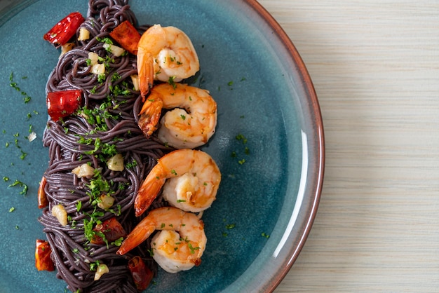 stir-fried black spaghetti with garlic and shrimps on plate