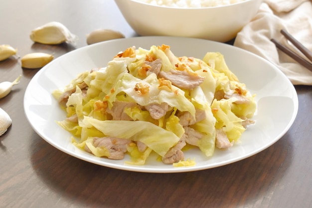 Stir fried cabbage with pork on a white plate