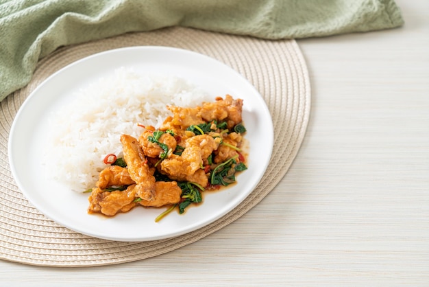 stir-fried fried fish with basil and chili in thai style topped on rice - Asian food style