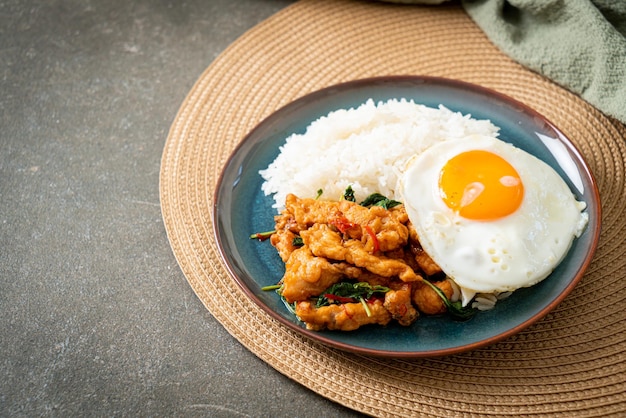 stir-fried fried fish with basil and fried egg topped on rice - Asian food style