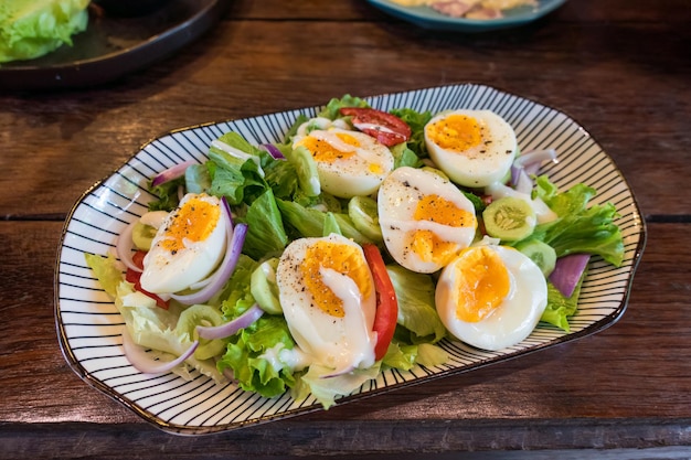 Stir fried mixed salad with boiled egg and sauce Healthy food in ceramid plate