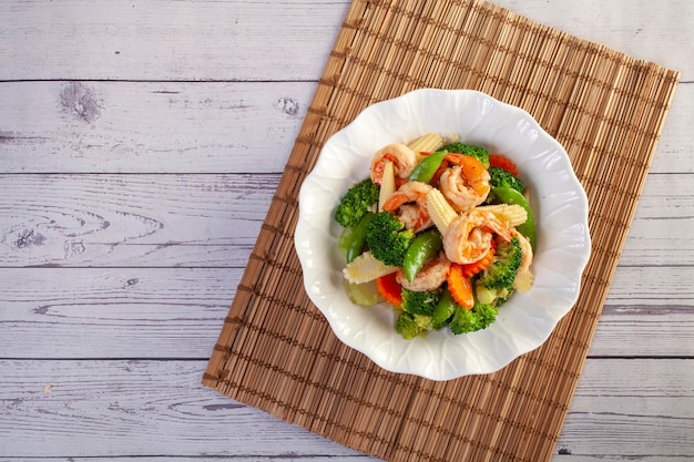 Stir fried mixed vegetables and shrimp on wooden table