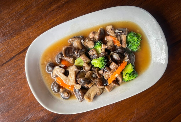 Stir fried mushroom with broccoli carrot vegetable shiitake mushrooms with oyster sauce cooking food on white plate shiitake mushroom cooked by frying