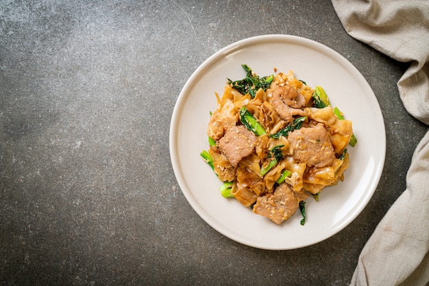 Stir-fried rice noodle with black soy sauce and pork and kale