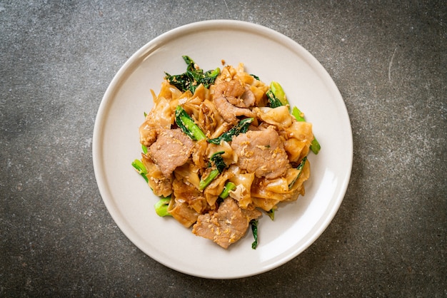 Stir-fried rice noodle with black soy sauce and pork and kale