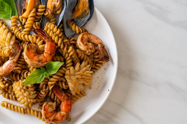 stir-fried spiral pasta with seafood and basil sauce - fusion food style