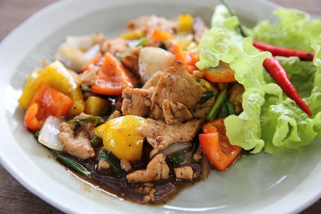 Stir fry chicken with black pepper on wood background