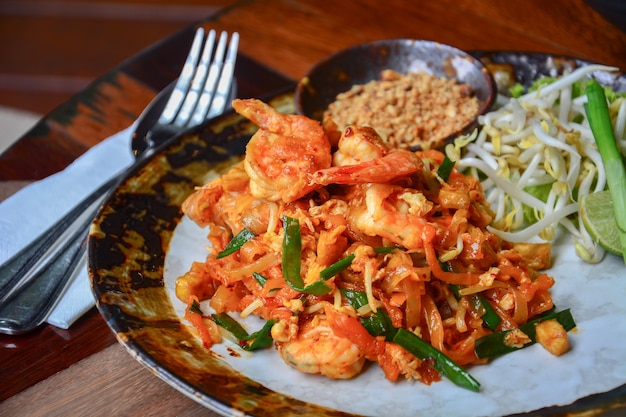 stir fry rice noodles with shrimps and vegetable or pad thai on wooden table background