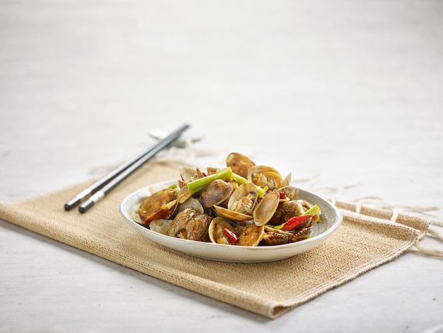 Stirfired Fragrant Lala with chopsticks on a dish isolated on wooden board side view on grey background