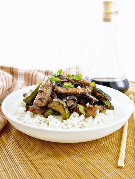 Stirfried of chicken with zucchini in plate on wooden board