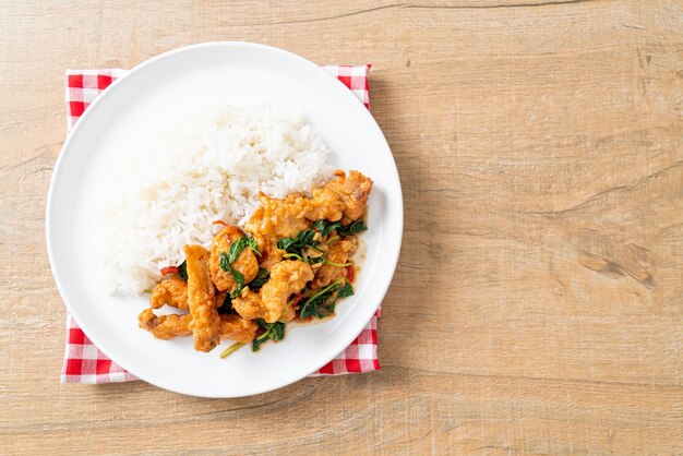 stirfried fried fish with basil and chili in thai style topped on rice