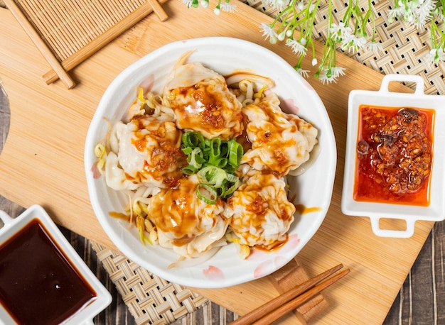 Stirfried Hands with Fresh Meat and Red Oil with sauce isolated on wooden cutting board top view