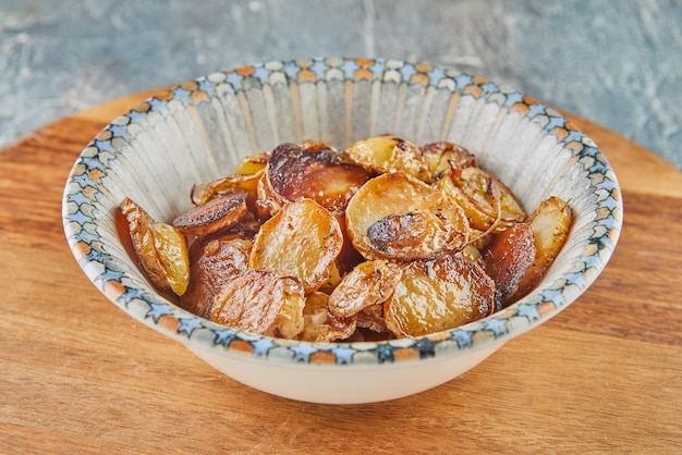 Stirfried potatoes in a plate on wooden board