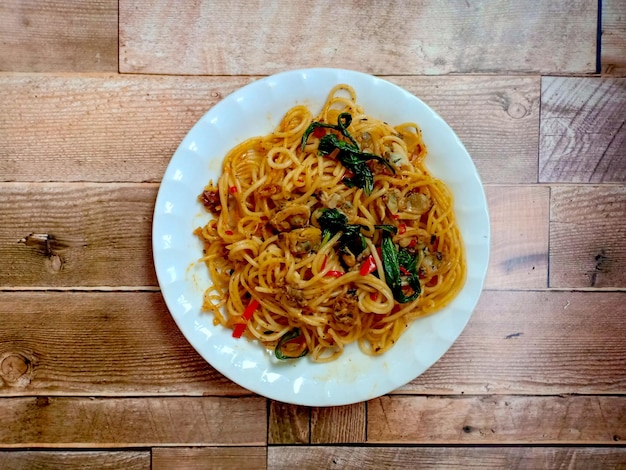 Stirfried spaghetti with clam on a wooden table