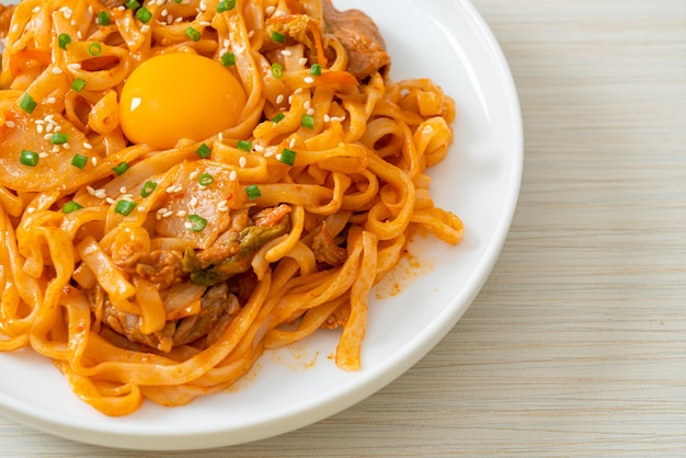 Stirfried udon noodles with kimchi and pork