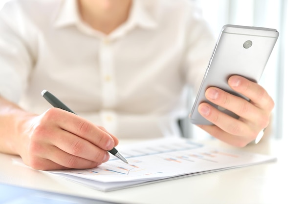 Stock broker sitting in office and checks business report