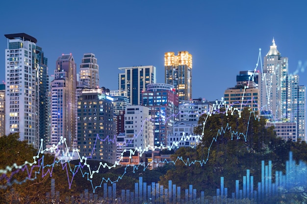 Stock market graph hologram night panorama city view of Bangkok popular location to gain financial education in Southeast Asia The concept of international research Double exposure