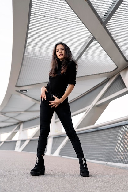 Stock photo of a portrait of a young woman looking at camera She is standing in the street