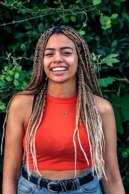 Stock photo of young african american woman smiling and looking at camera. She has cool braids.