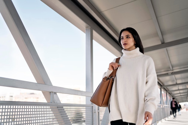 Stock photo of a young business woman walking on the street. She is wearing casual clothes.