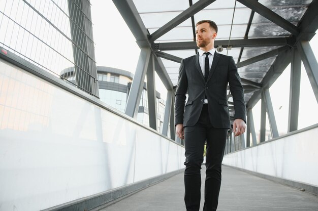 Stockbroker near the office A successful and advanced handsome business man in a suit looks up in front of him standing on the background of concrete steps