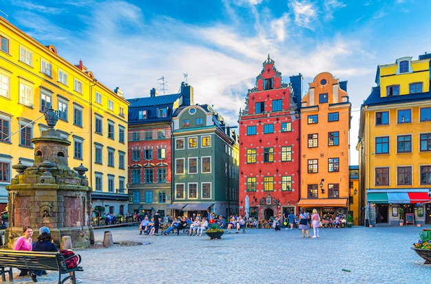 Stockholm traditional typical colorful buildings fountain and people tourists on Stortorget square