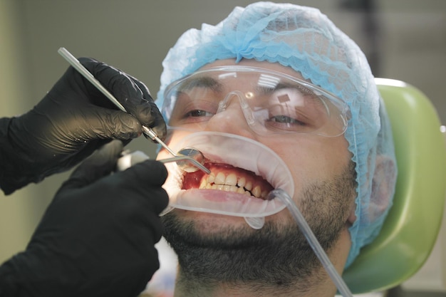 Stomatology healthcare - male patient at dentist's chair, close up