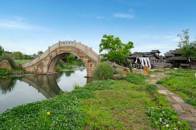 Photo the stone arch bridge over the lake in the countryside of the village