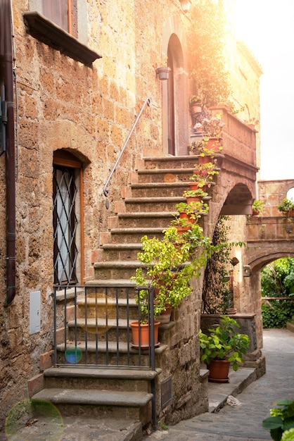 A stone building with a staircase and a planter on the left side.