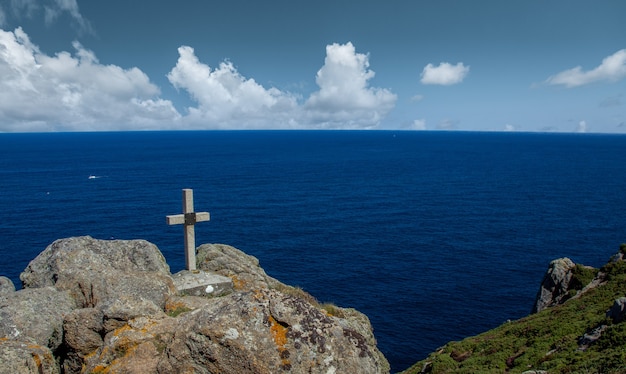 Stone cross on top of a hill facing the sea in Galicia, Spain