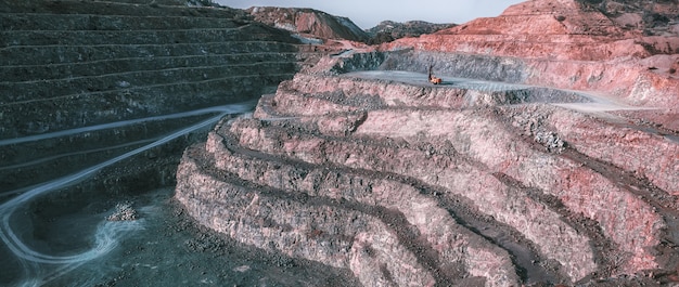 Stone crusher machine on top of open pit mine terraces Panorama of gravel quarry