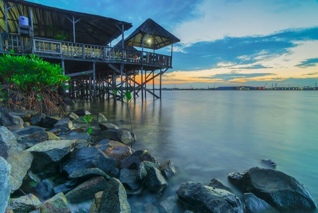 Stone and House on stilts in sunset Batam island