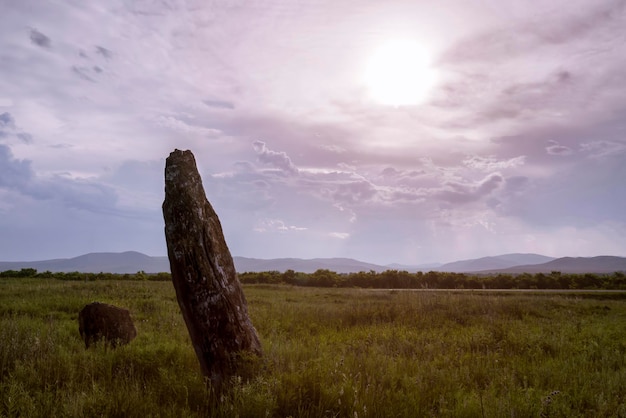 A stone idol is an image of copyspace in the steppe under the sunset sky of khakassia a fragment of