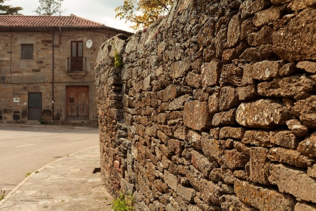 a stone old wall in a little village street