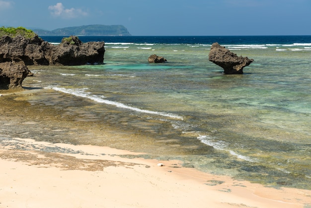 Stone platform appearing out on low tide emerald green sea. Rock formation typical from coastal region.