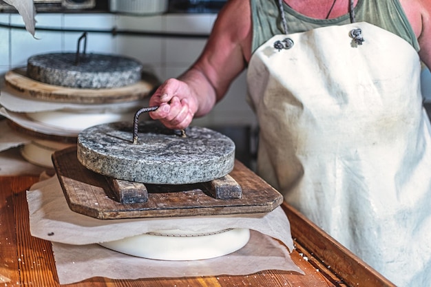 Stone press for creating the typical shape of locally produced cheese from Bergamo in northern Italy