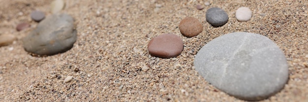 Stone put in human foot shape on sand hot summer day coastline sandy beach