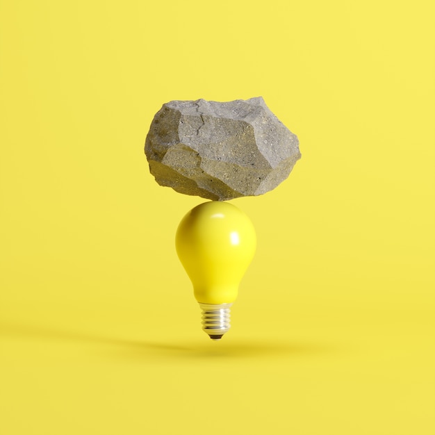 Stone put on yellow light bulb floating on yellow background