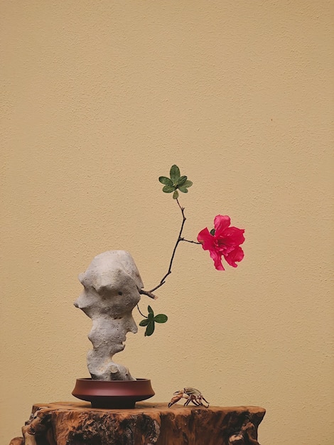 A stone sculpture of a flower is on a table.