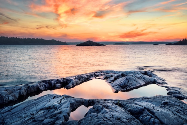 Stone shore of the lake at sunset