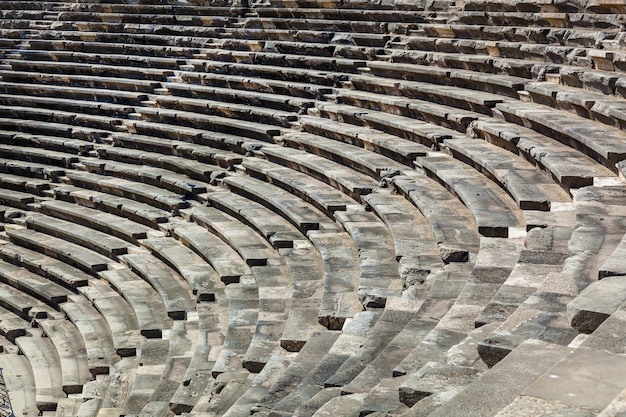 Stone steps of an old amphitheater from ancient times in the region of Antalya, Side, Turkey.