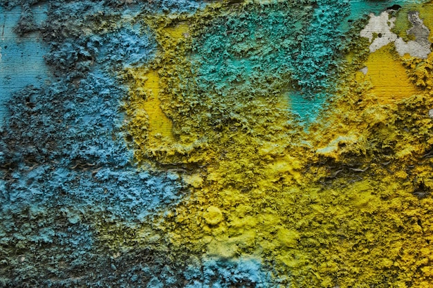 Stone texture painted with colors of ukrainian flag Blue yellow color stripes paint on rough limestone wall surface