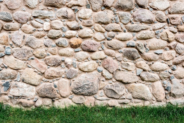 Stone wall with green grass background.