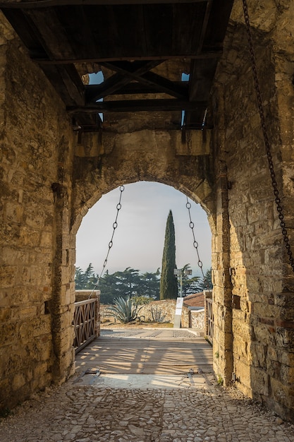 Stone wall with merlons and drawbridge Gate of medieval Castle of Brescia or Castello di Brescia or Falcon of Italy,